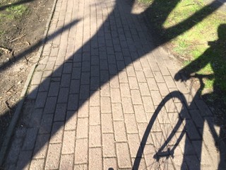 Der Schatten eines Fahrradfahrers auf einem Weg