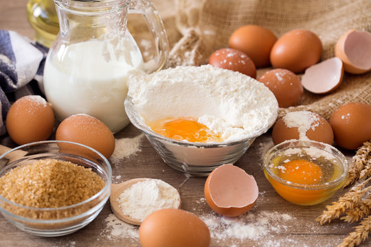 Breaking eggs into flour to baking cakes.