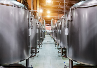 Rows of steel tanks for beer fermentation and maturation. - obrazy, fototapety, plakaty