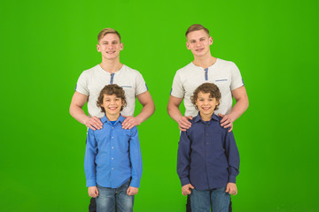 The four attractive brothers stand on the green background