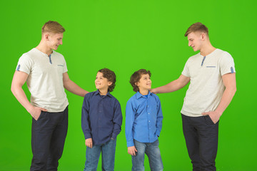 The four happy brothers stand on the green background