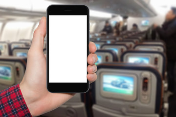 A man's hand with a smartphone on the background of the interior in the airplane. In a blank screen you can write information