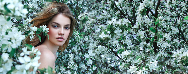 Fototapety  Piękna młoda dziewczyna leży na polanie wśród białych kwiatów. Białe kwiaty. Rumianek. Dziewczyna z włosami w białej sukni.