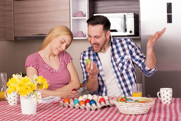 Couple Having Fun while Cracking Colored Easter Eggs