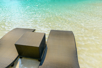 Beach chairs in luxury swimming pool.