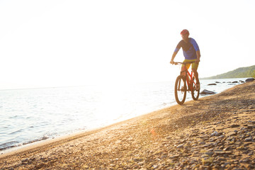 Fototapeta na wymiar Man riding a mountain bike on the beach