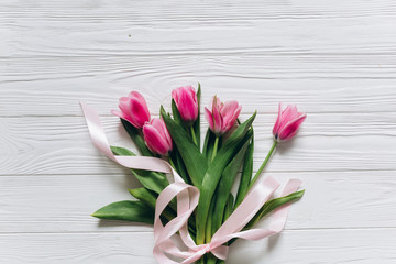 Fresh tulips on a white wooden background for Mother's Day.