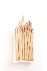 Bunch of white asparagus spears in a box, on white background