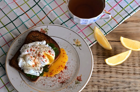 eggs pashot on a toast and tea with lemon