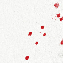 Closeup splashed red drop on white wall