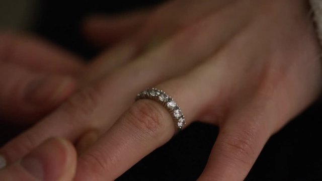 4K Man puts engagement ring on female's finger