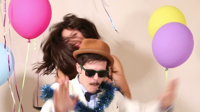 Two funny friends having awesome time dancing in party photo booth