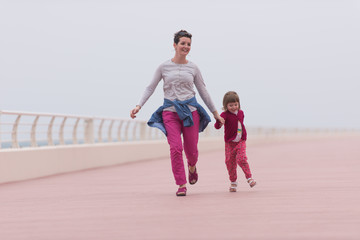 mother and cute little girl on the promenade by the sea