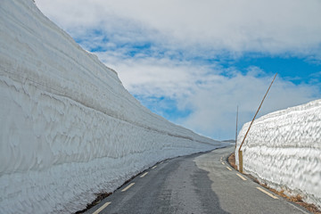 Snow wall on the road Tindevegen - the highland road in Norway.