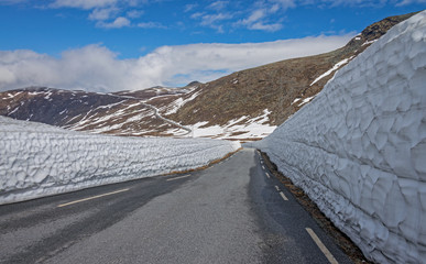 Snow wall on the road Tindevegen - the highland road in Norway.