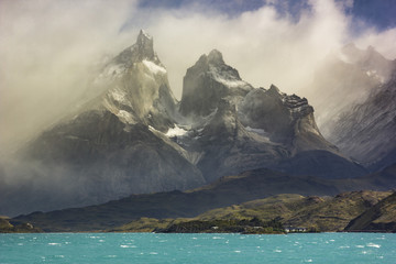 mountains of patagonia in haze at sunrise near blue lake