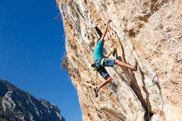 Climber making risky Move on dangerous Rock