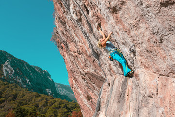 Female Rock Climber on high Wall