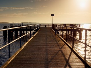 Fototapeta na wymiar Long wooden pier at coast, cold morning, peaceful silent day