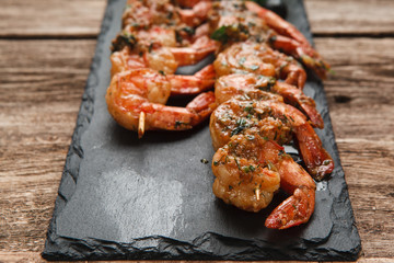 Japanese cuisine. Fried shrimps served on black slate, close up view. Restaurant menu photo, free space for text