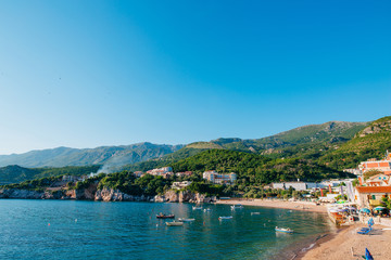 Fototapeta na wymiar Przno, Montenegro. Beach, sun beds and umbrellas on the beach, the beach line.