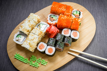 Traditional food. Japanese food - sushi rolls, sauce and chopsticks on a dack background. Top view. Flat lay