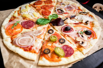 Tasty pizza on black background. Flat lay, top view.