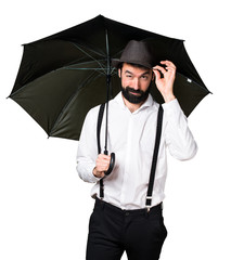 Hipster man with beard holding an umbrella