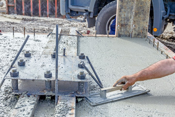 Worker is leveling concrete after pouring