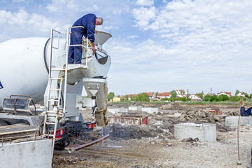 Worker is washing concrete mixer