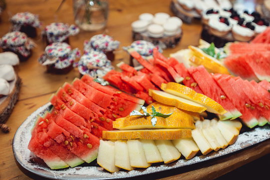 sliced watermelon and malon on a wooden table