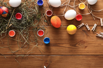 Painting colorful easter eggs background, top view on wood