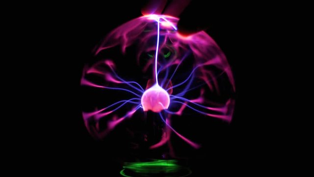 Plasma Ball And Lightning. High voltage. Tesla generator. Close-up view of plasma ball with moving energy rays inside on black background. Electric ball on the black background.