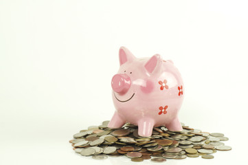 piggy bank on pile of money coin isolated on white background