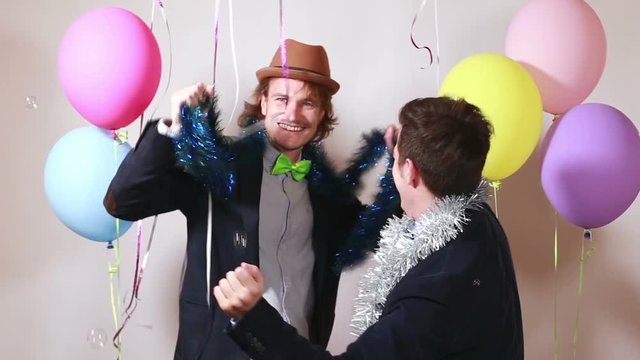Two funny friends having fun dancing with props in party photo booth