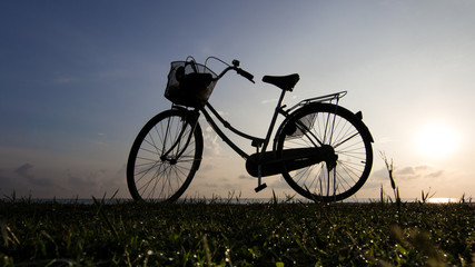 Obraz na płótnie Canvas Bicycle beach sunrise silhouette