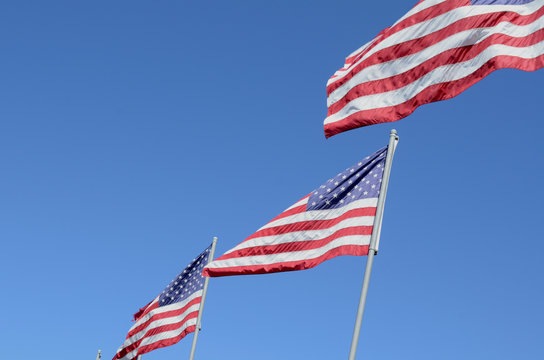 American flags on flag poles b;owing in wind
