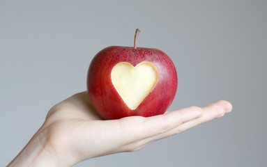 hand with an apple symbolizing love and health.