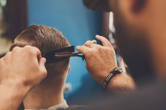 Man getting haircut by hairstylist at barbershop