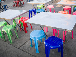 Outdoor metal table and colored plastic chair, street food scene in Thailand, nobody