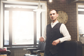 Barber invites to have seat on chair at barbershop