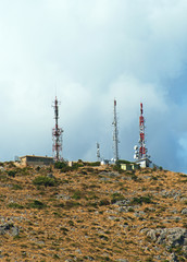 Telecommunication towers with antennas on the hill.
