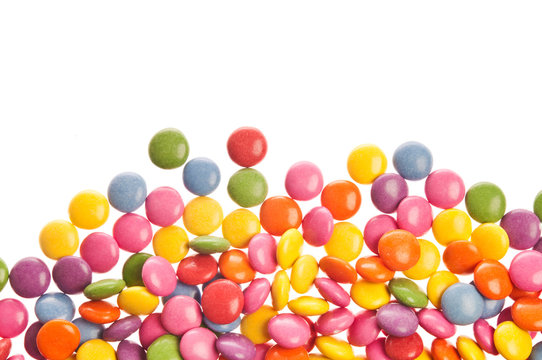many colorful sugar coated candy, candies over white background 