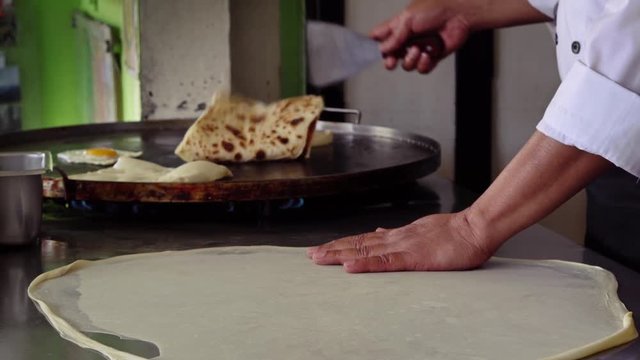 Man cooking Indian bread roti
