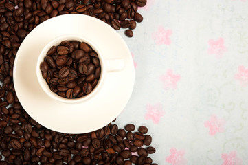 modern white espresso  cup filled with coffee beans over romantic background and copy space