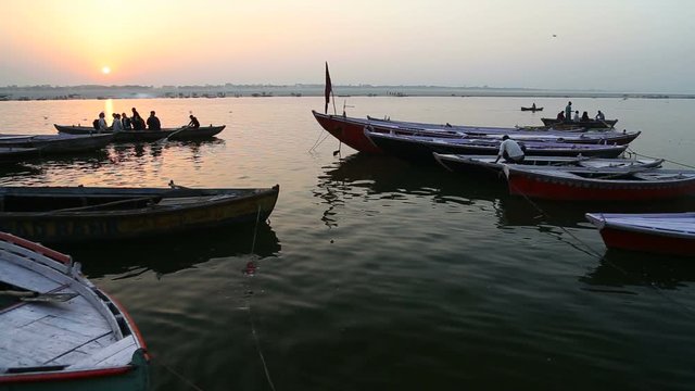 Boat sailing through river Ganges at sunset.