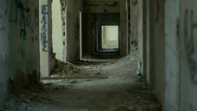 Gimbal steadicam pov shot of someone exploring the corridors and rooms of a huge demolished abandoned building.