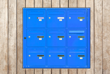 boîtes aux lettres bleues incrustées dans panneau de bois