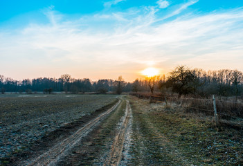 Sunrise over muddy farmland in winter
