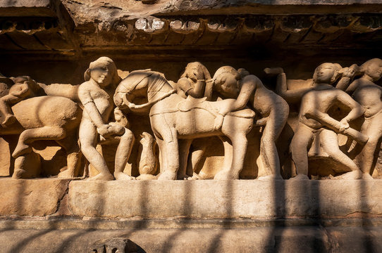 Intimate life of ancient people on stone relief on wall of Khajuraho temple, India.